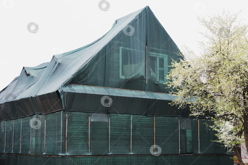 Скачать Старый нежилой дом покрыт строительной сеткой фотосток Ozero