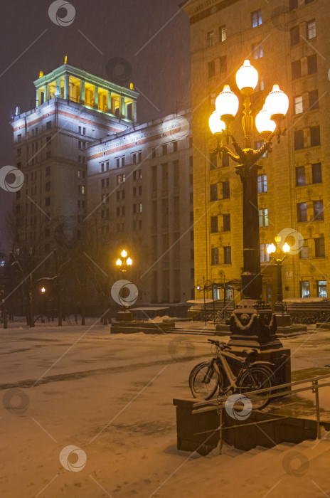 Скачать Заснеженные велосипеды, прислоненные к фонарному столбу. фотосток Ozero