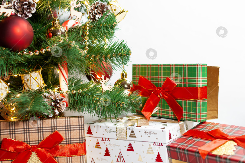 Скачать Уныло украшенная рождественская елка. Подарочная коробка с крышкой в шотландскую клетку под искусственно украшенной рождественской елкой. Канун Рождества и нового года. Ноэль. Новая анни. фотосток Ozero