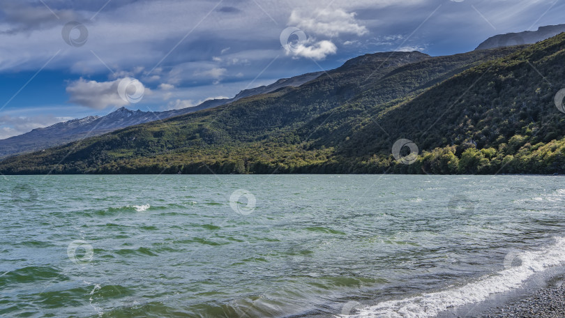 Скачать Волны изумрудного озера пенятся на галечном берегу. фотосток Ozero