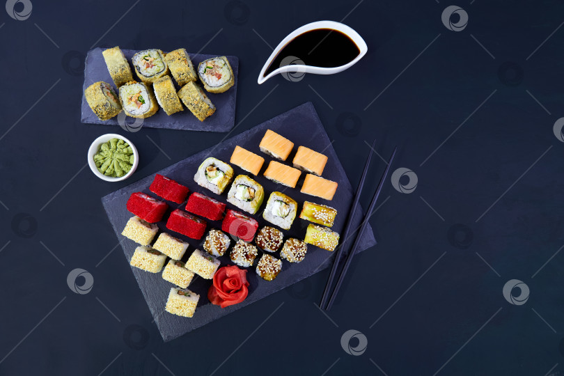 Скачать Большой набор суши. Японская кухня. Ассорти из различных суши-роллов с тунцом, лососем, угрем, авокадо, икрой летучей рыбы. фотосток Ozero