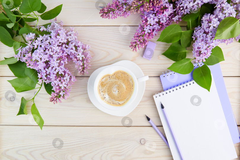 Скачать Ветви сирени, чашка кофе с молоком, блокнот с карандашами на деревянном фоне. Весенний фон. фотосток Ozero