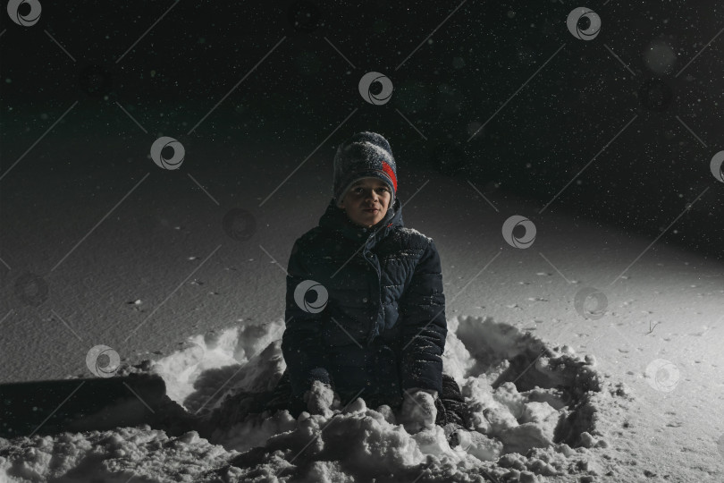 Скачать Маленький мальчик играет вечером в снегу фотосток Ozero