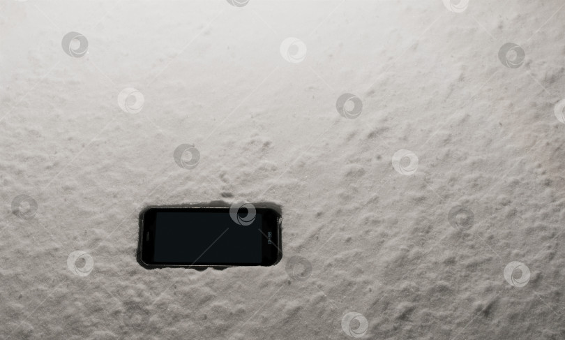 Скачать Защитный смартфон лежит в снегу фотосток Ozero