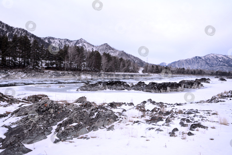 Скачать Скалистые выступы по берегам и русло замерзшей реки в горной долине ранним зимним утром. фотосток Ozero
