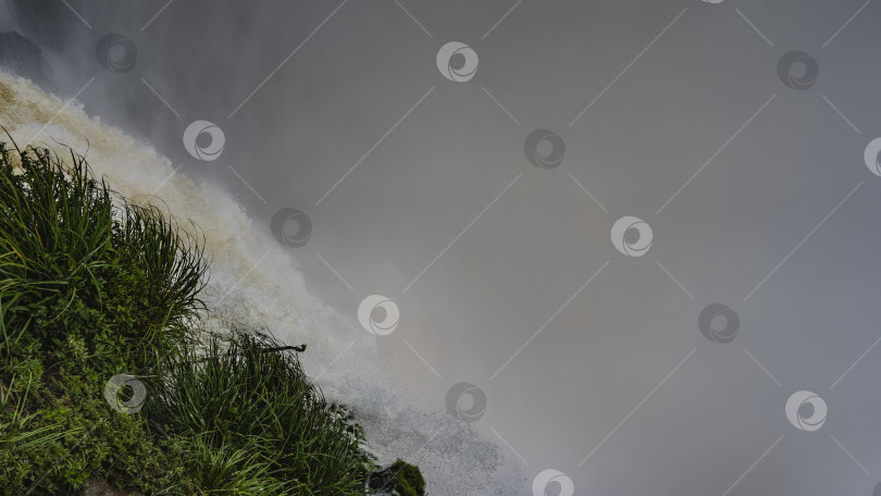 Скачать Бурный поток воды низвергается в пропасть со скалы. фотосток Ozero