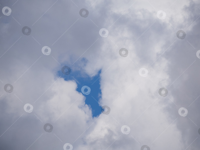 Скачать Голубой просвет неба в сплошных белых облаках. Кучевые облака с окном голубого неба фотосток Ozero