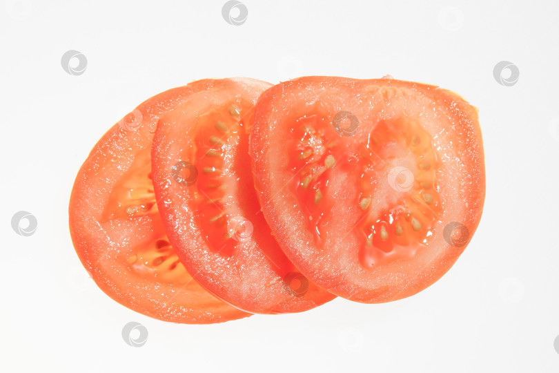 Скачать Нарезанные ломтиками свежие красные помидоры, выделенные на белом фоне фотосток Ozero
