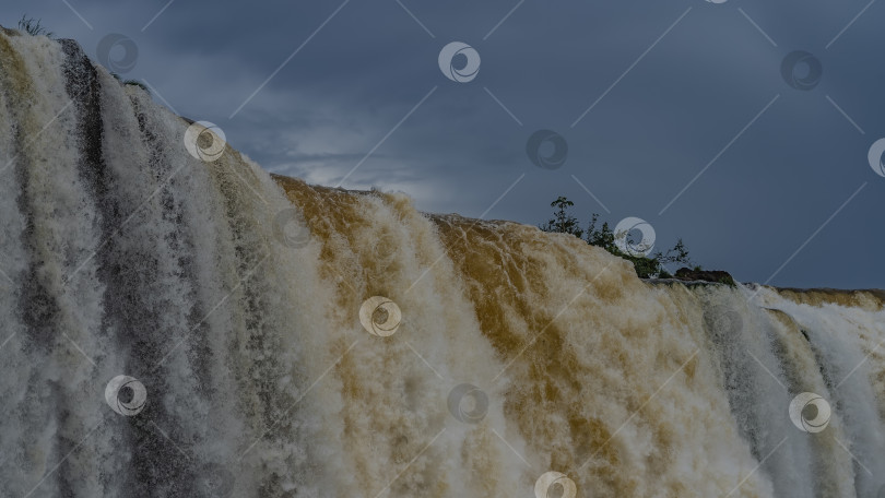 Скачать Бурлящие потоки водопада низвергаются с края уступа. фотосток Ozero