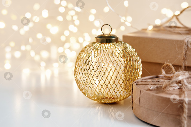 Скачать Рождественские устойчивые подарочные коробки с металлическим золотым шаром на сияющем фоне боке. Рождество без отходов, день подарков и зимние каникулы фотосток Ozero