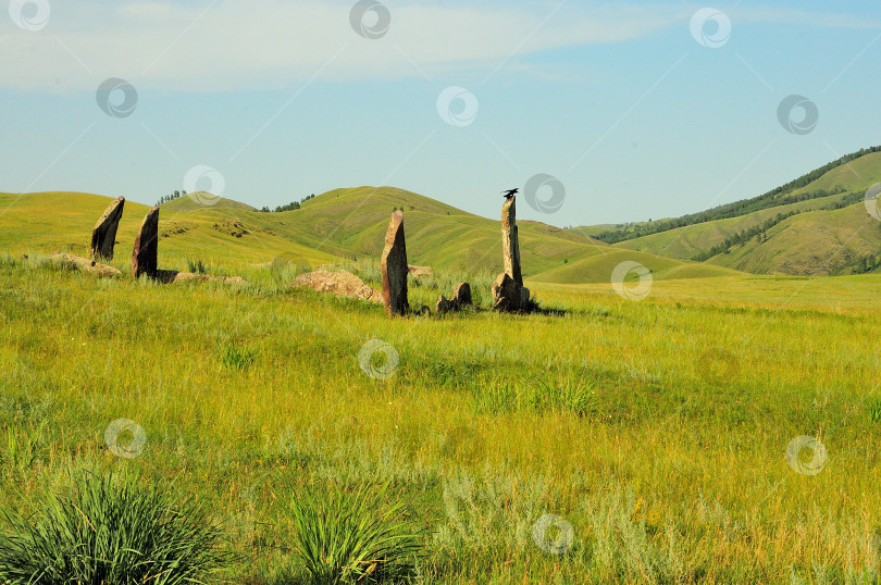 Скачать Группа древних могильных камней в живописной холмистой долине теплым летним днем. фотосток Ozero