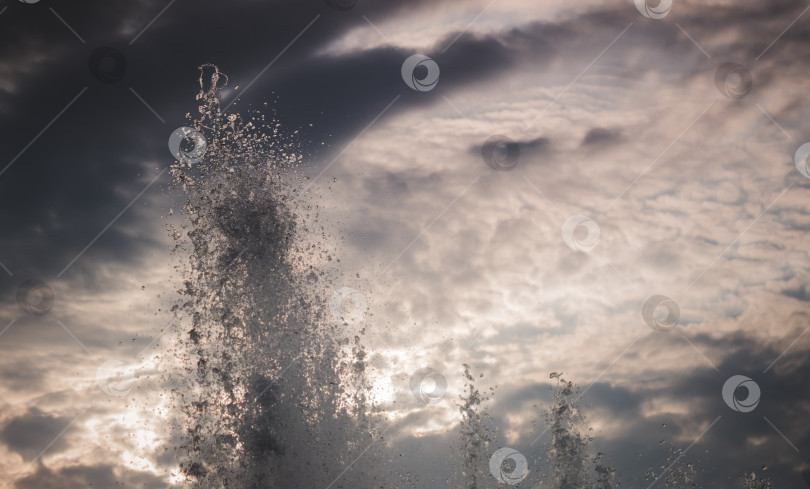 Скачать Всплеск фонтана на фоне неба в ветреный день фотосток Ozero