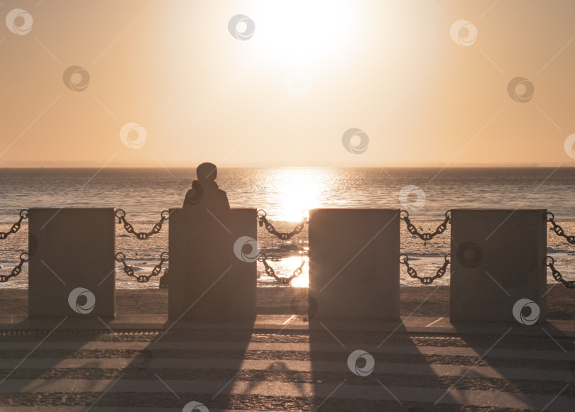 Скачать фигура мужчины, смотрящего на закат.Зимний вечер на берегу моря. фотосток Ozero