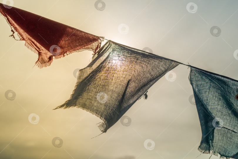 Скачать Красочные молитвенные флаги с солнцем, просвечивающим сквозь один из молитвенных флагов фотосток Ozero