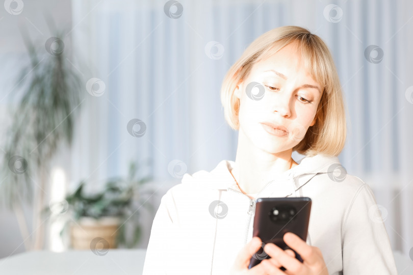 Скачать Изображение красивой женщины крупным планом, сидящей в уютном домашнем интерьере и пользующейся современным смартфоном, женские руки, набирающие текстовое сообщение по мобильному телефону, концепция социальной сети фотосток Ozero