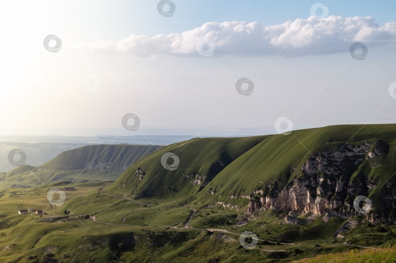 Скачать Пейзаж с зелеными холмами, горами и голубым небом. Красивая природная панорама с пространством для копирования. фотосток Ozero