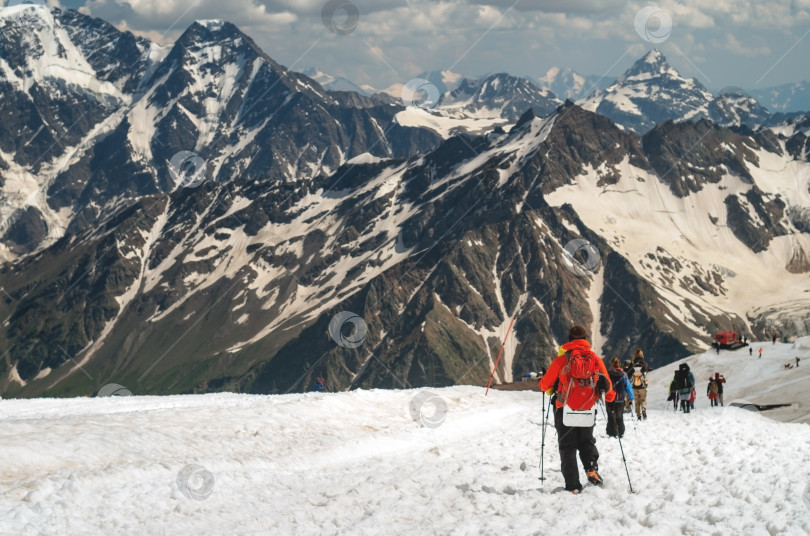 Скачать Группа туристов с рюкзаками спускается по заснеженному ледяному склону. фотосток Ozero