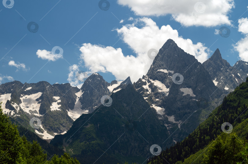 Скачать Красивый горный пейзаж со снежными вершинами и облаками. фотосток Ozero