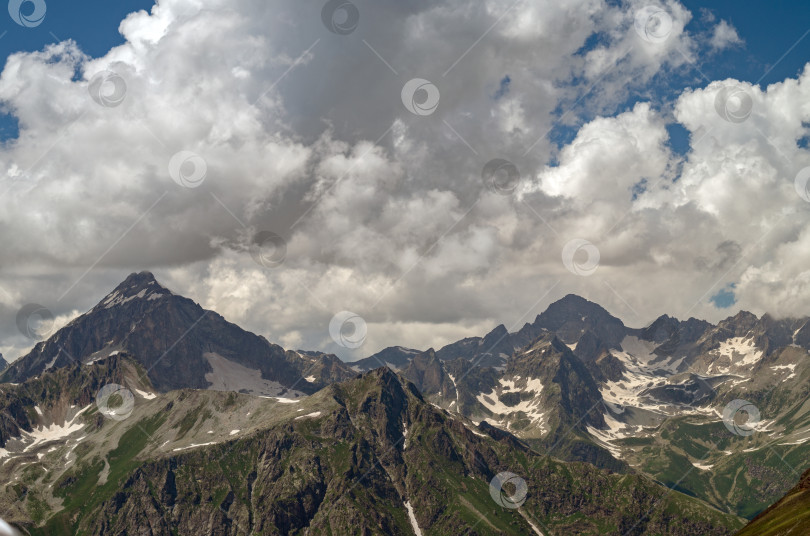 Скачать Красивый горный пейзаж со снежными вершинами и облаками. высокогорье летом. фотосток Ozero