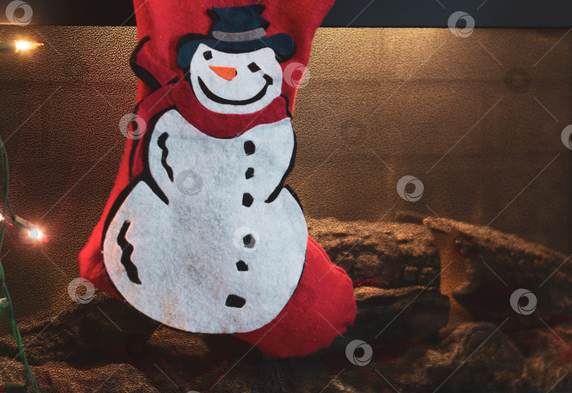Скачать На каминной полке висит рождественский чулок с изображением снеговика фотосток Ozero