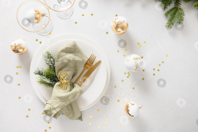 Скачать Красивая рождественская праздничная сервировка стола с белой тарелкой, золотыми шариками на белом. фотосток Ozero