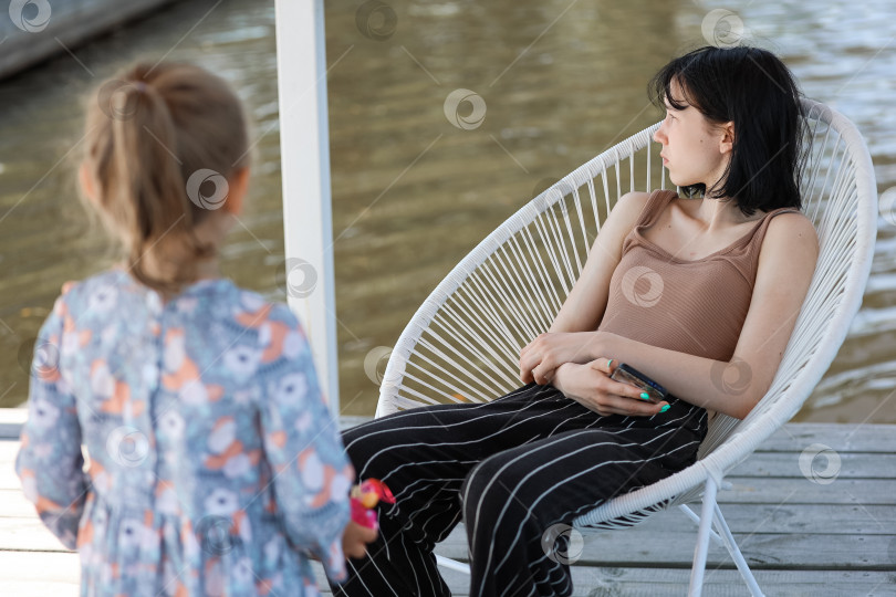 Скачать Две девушки болтают в беседке у воды фотосток Ozero