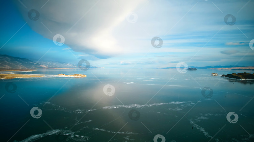 Скачать Замерзшее озеро Байкал, прозрачный лед. Линзовидное облако над озером. фотосток Ozero