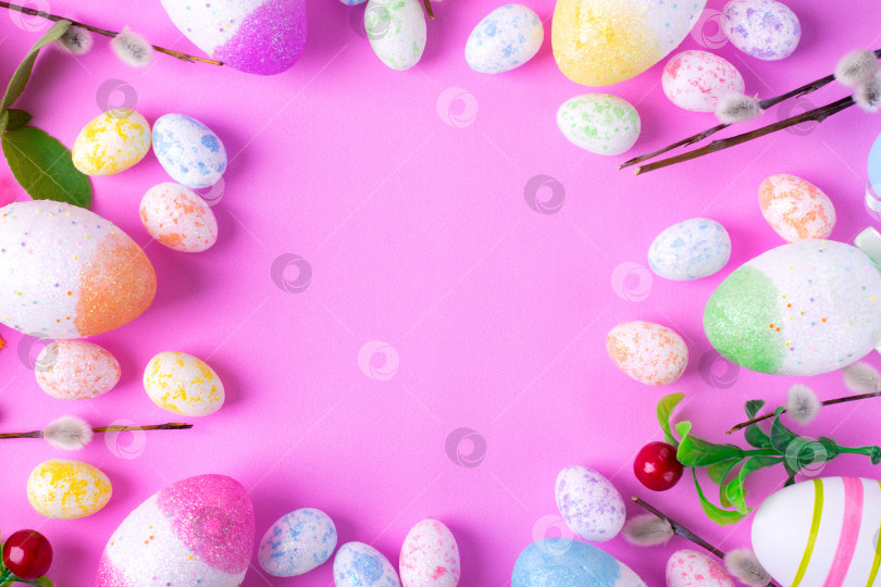 Скачать Пасхальный фон с разноцветными декоративными яйцами и ивовыми прутьями, обрамляющими пространство копии на розовом фоне. Праздничная плоская лежанка. фотосток Ozero