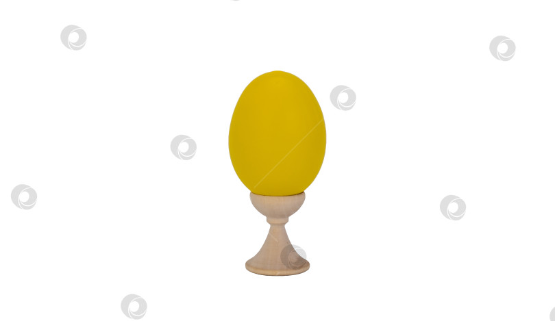 Скачать желтое пасхальное яйцо на деревянной подставке, белый фон. атрибут празднования древнейшего христианского праздника Пасхи. набор ярких штучек фотосток Ozero