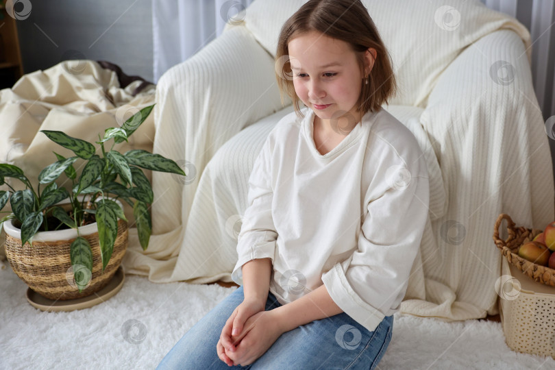 Скачать Портрет смеющейся девушки, сидящей на ковре в гостиной фотосток Ozero