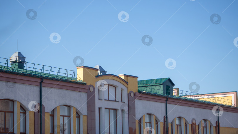 Скачать Разноцветное кирпичное здание с зеленой крышей на фоне неба. Элементы архитектуры фотосток Ozero