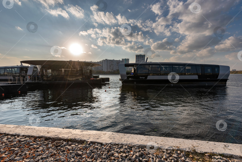 Скачать Электрический речной трамвайчик подходит к пристани "Печатники" на закате фотосток Ozero