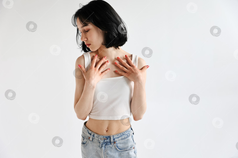 Скачать Молодая симпатичная девушка-подросток в джинсах и рубашке на белом фоне фотосток Ozero