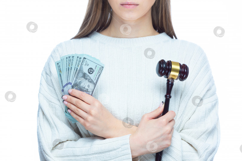 Скачать Крупным планом женщина со скрещенными на груди руками держит молоток и долларовые банкноты. Понятие коррупции, взяток, несправедливого судебного разбирательства фотосток Ozero