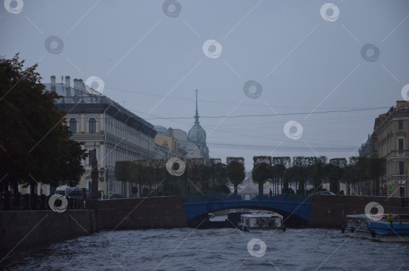 Скачать Санкт-Петербург, Россия – 09.24.2023: Вид на Синий мост и городскую историческую застройку Санкт-Петербурга в дождливый день фотосток Ozero