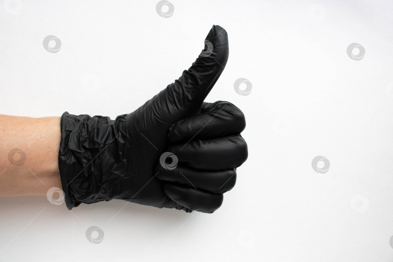 Скачать Рука в черной хирургической медицинской перчатке, выделенная на белом фоне. Производство резиновых защитных перчаток.Гигиена и санитарные нормы фотосток Ozero