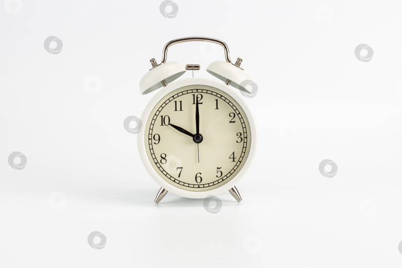 Скачать Белые ретро-часы-будильник на белом фоне показывают 10:00 утра, или вечера, или 22:00 фотосток Ozero