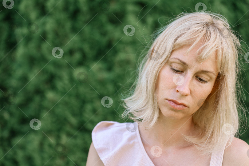 Скачать Портрет светловолосой женщины в саду на зеленом фоне фотосток Ozero