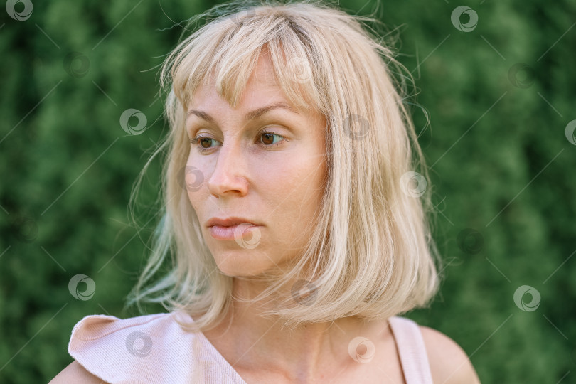Скачать Портрет светловолосой женщины в саду на зеленом фоне фотосток Ozero