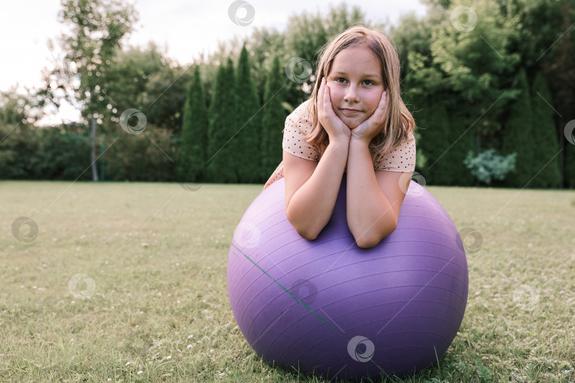 Скачать Девочка играет с большим мячом на лужайке во дворе дома жарким летом, концепция здорового образа жизни фотосток Ozero
