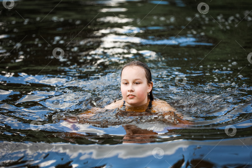 Скачать Девушка плавает в реке жарким летним днем фотосток Ozero