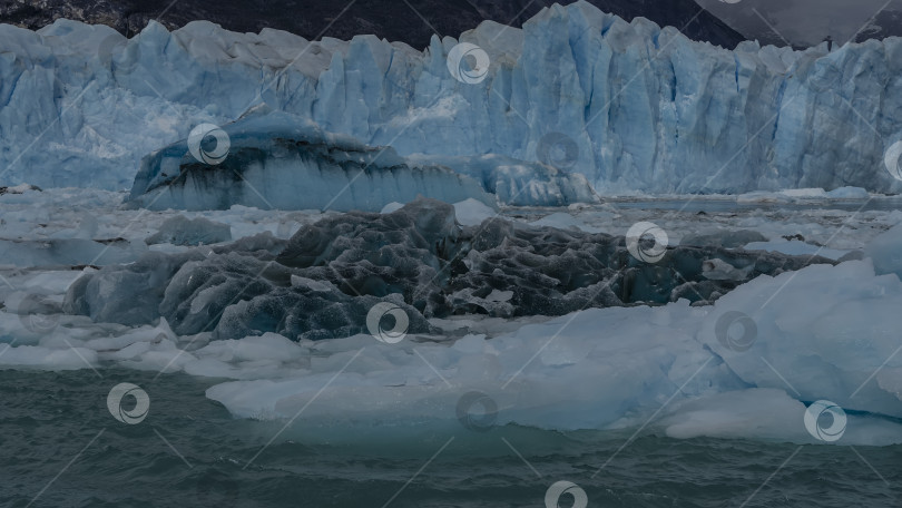 Скачать Темно-синие и светлые подтаявшие льдины, разбитые айсберги плавают в бирюзовом озере. фотосток Ozero