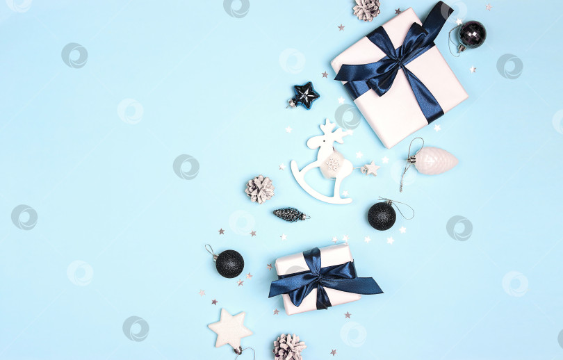Скачать Рождественская рамка с подарками и белыми украшениями на синем фоне. фотосток Ozero