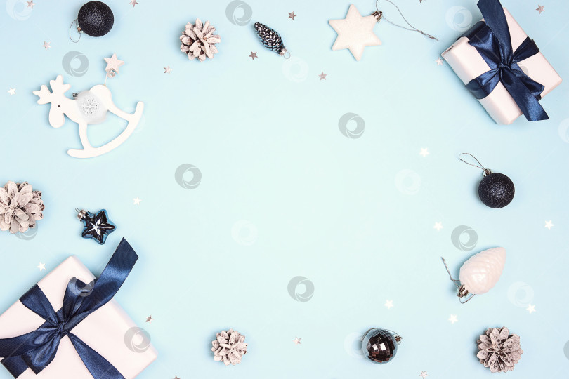 Скачать Праздничная зимняя рамка с подарками и белыми украшениями на синем фоне. фотосток Ozero