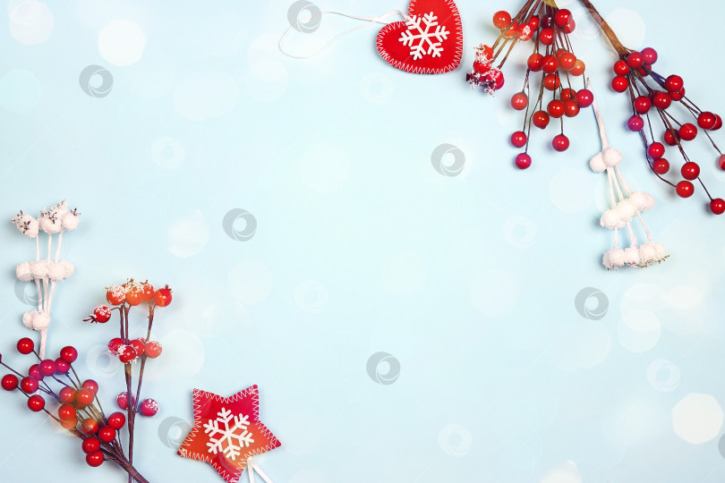 Скачать Рождественская кайма из красных ягод и украшений на синем фоне. фотосток Ozero