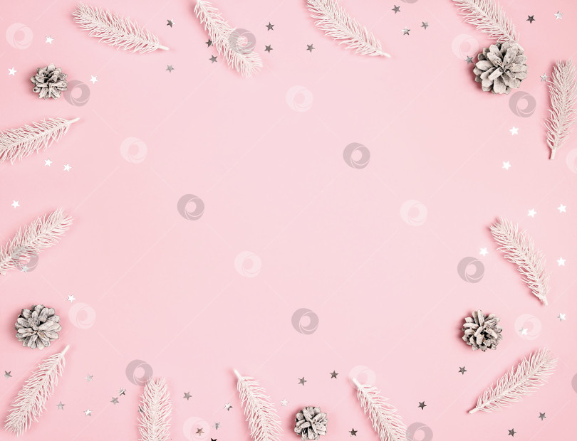 Скачать Рождественская рамка из белых еловых веток, шишек и звезд на розовом фоне. фотосток Ozero