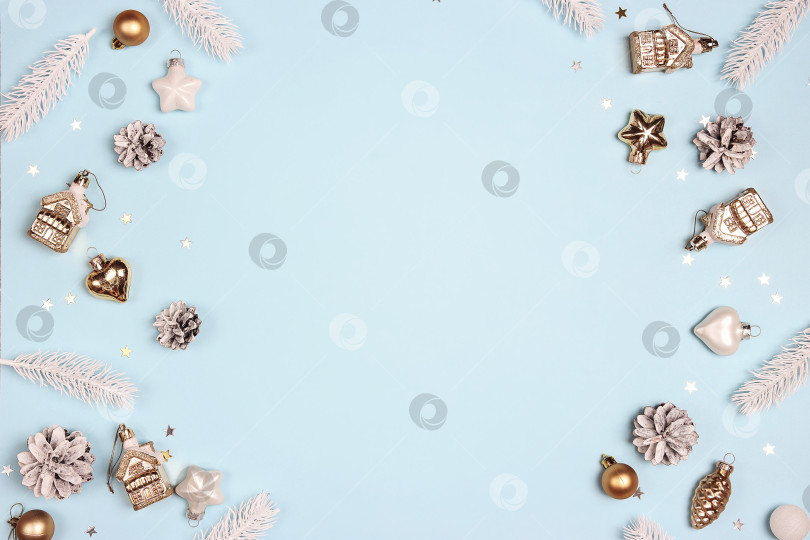 Скачать Рождественская рамка из золотых и белых украшений и еловых веток на синем фоне. фотосток Ozero