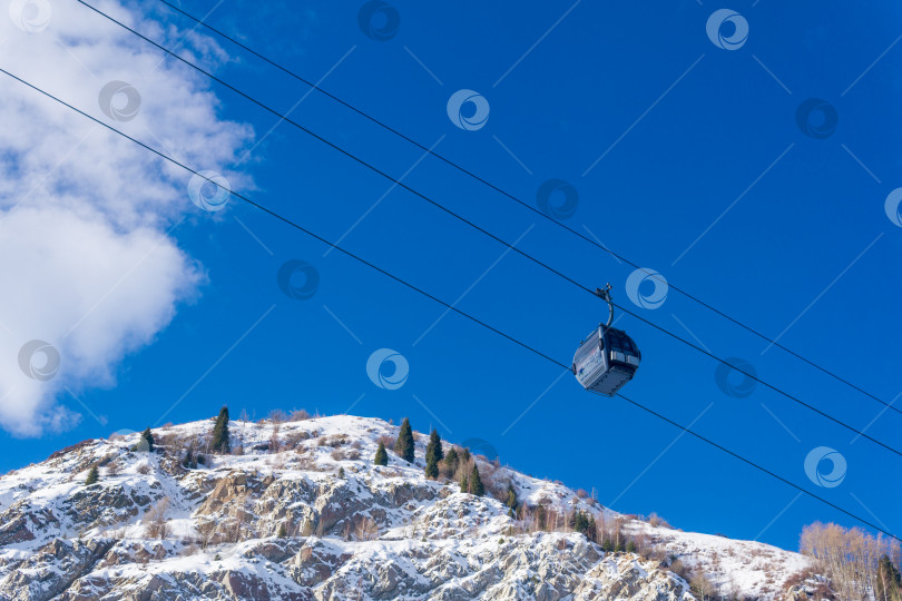 Скачать канатная дорога для лыжников на фоне голубого неба и заснеженных горных склонов, вид снизу вверх фотосток Ozero