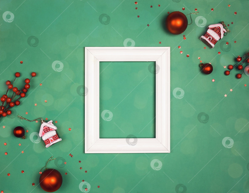 Скачать Пустая белая фоторамка с праздничными красными украшениями на зеленом фоне. фотосток Ozero