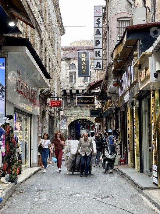 Скачать 14 апреля 2023 года - Стамбул, Турция: Городская жизнь, люди на узкой улочке возле Гранд Базара фотосток Ozero